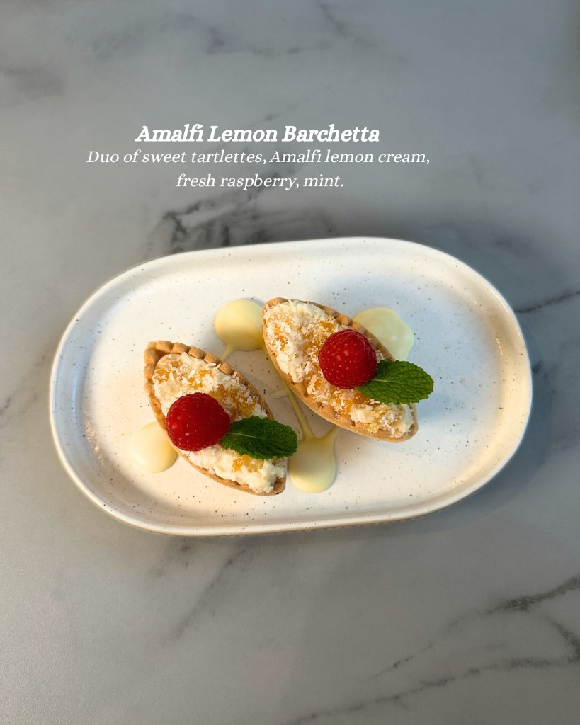 Amalfi lemon tartlets with raspberries on speckled plate