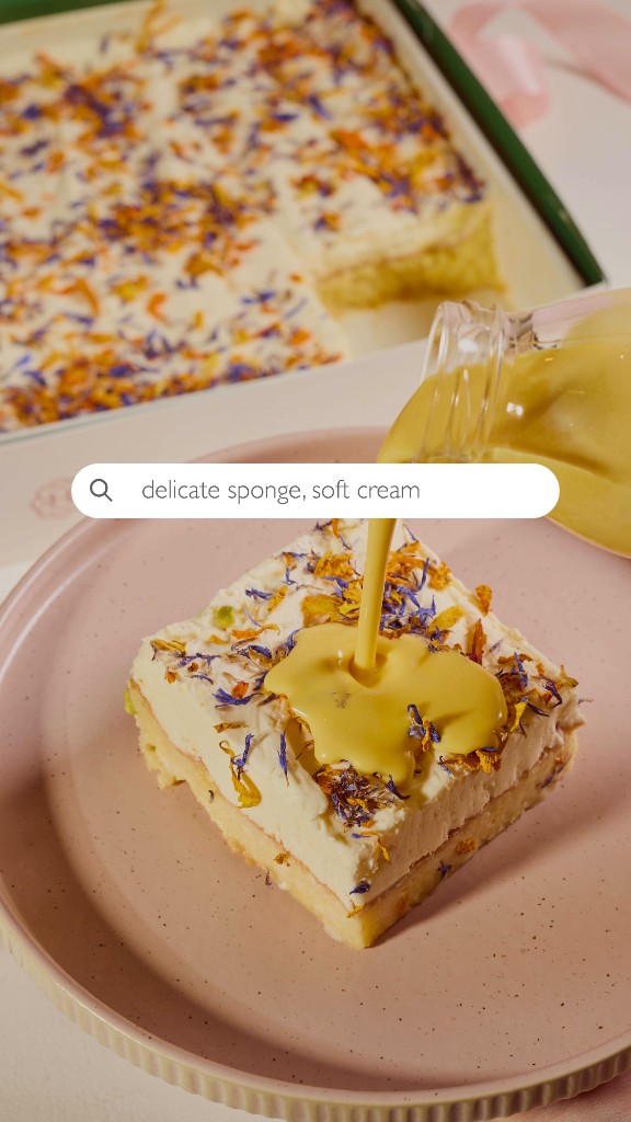 Layered sponge cake with cream and flower petals as sauce is poured